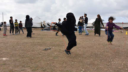 Barn i ett läger i Syrien hoppar hopprep.