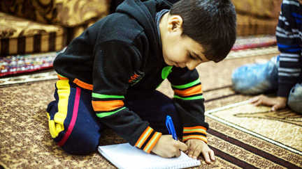 En liten pojke skriver ett brev