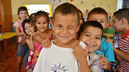 En grupp glada barn i ett klassrum i en skola som stöds av Rädda Barnen